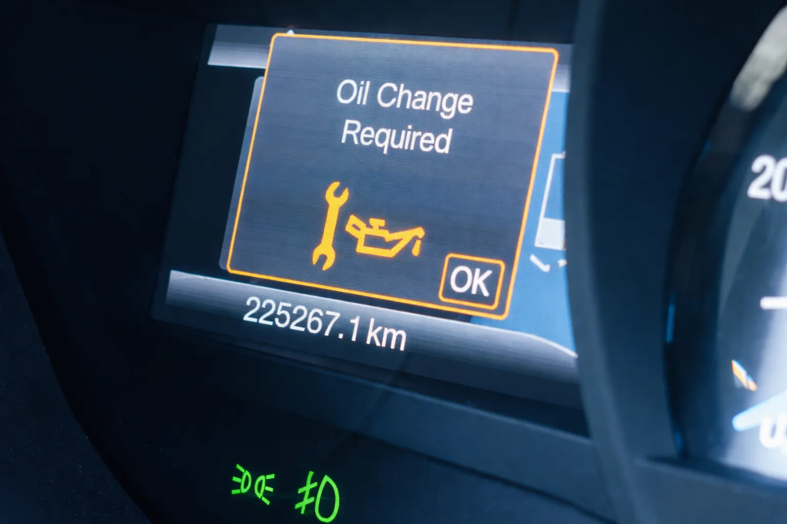 Car dashboard displaying an alert that says ‘Oil Change Required’ along with mileage information, indicating the need for timely oil replacement to maintain engine performance.