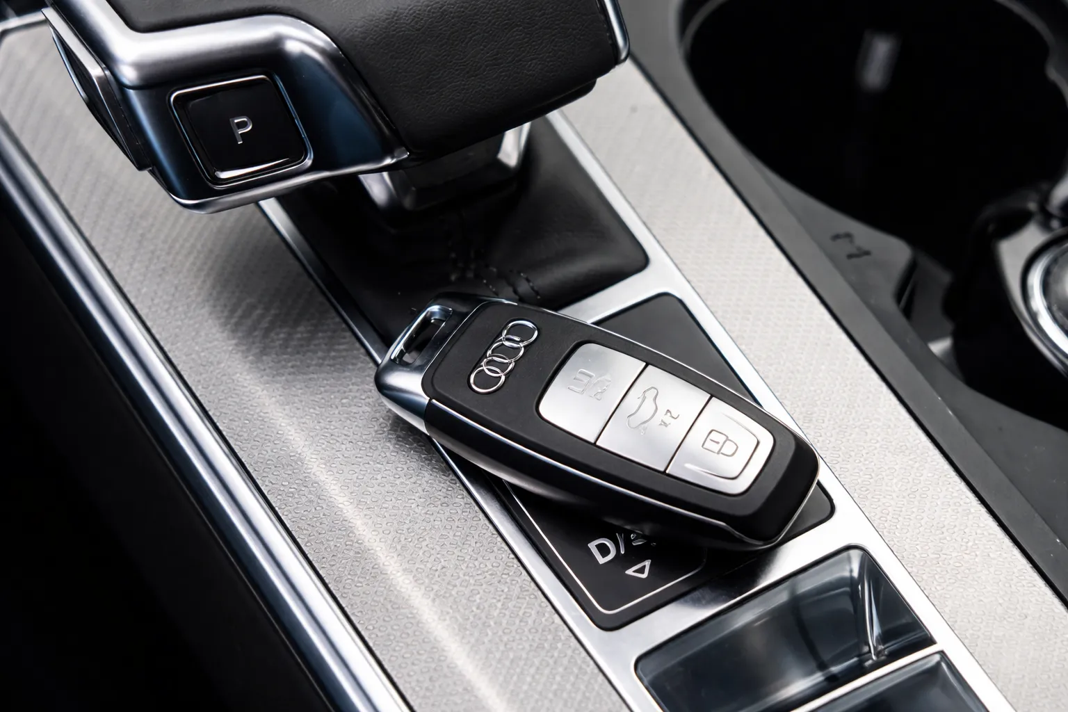 Close-up of an Audi key fob placed on a modern car’s center console beside the gear selector, highlighting smooth functionality and control after an Audi A5 transmission service.