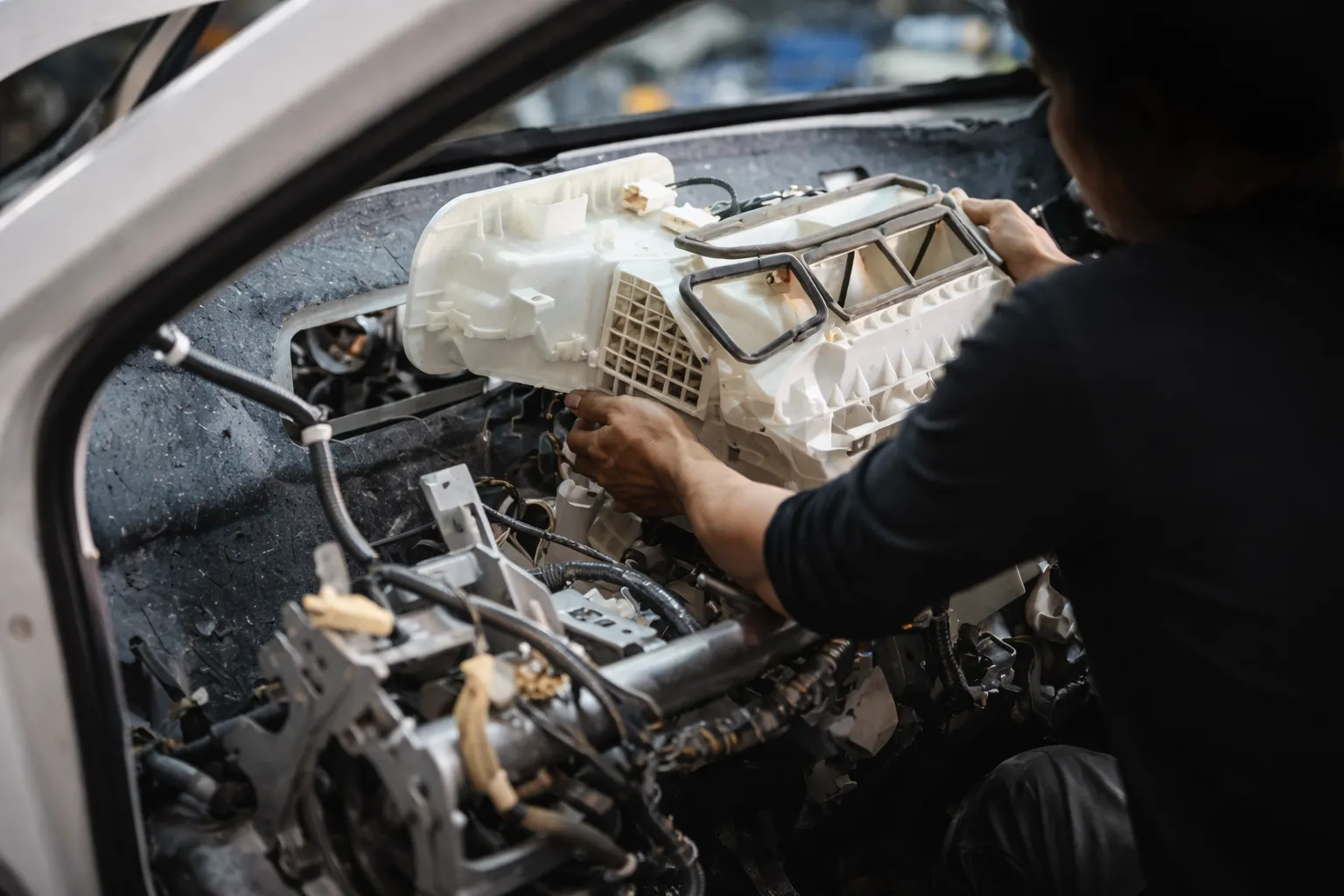 Mechanic removing the dashboard unit to access the AC system, performing a Haval AC Evaporator Replacement to restore proper cooling performance inside the vehicle.