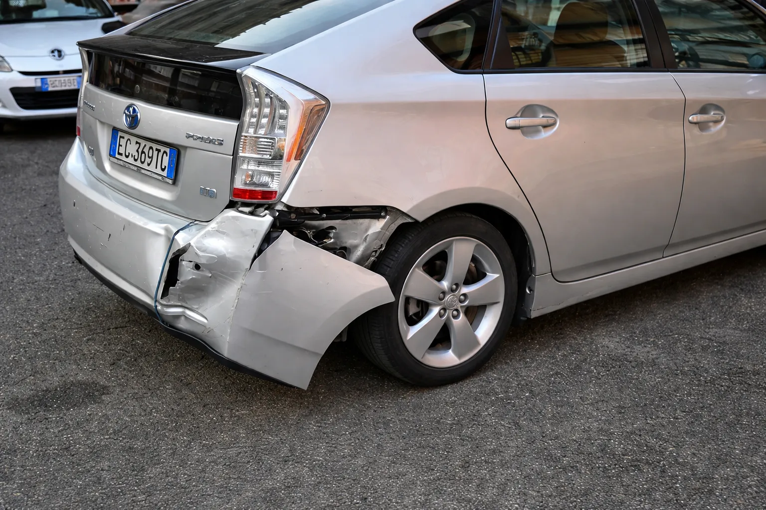 Damaged Toyota car with a dented rear bumper and exposed paneling, highlighting the need for professional repair services at a Toyota body shop in Dubai.