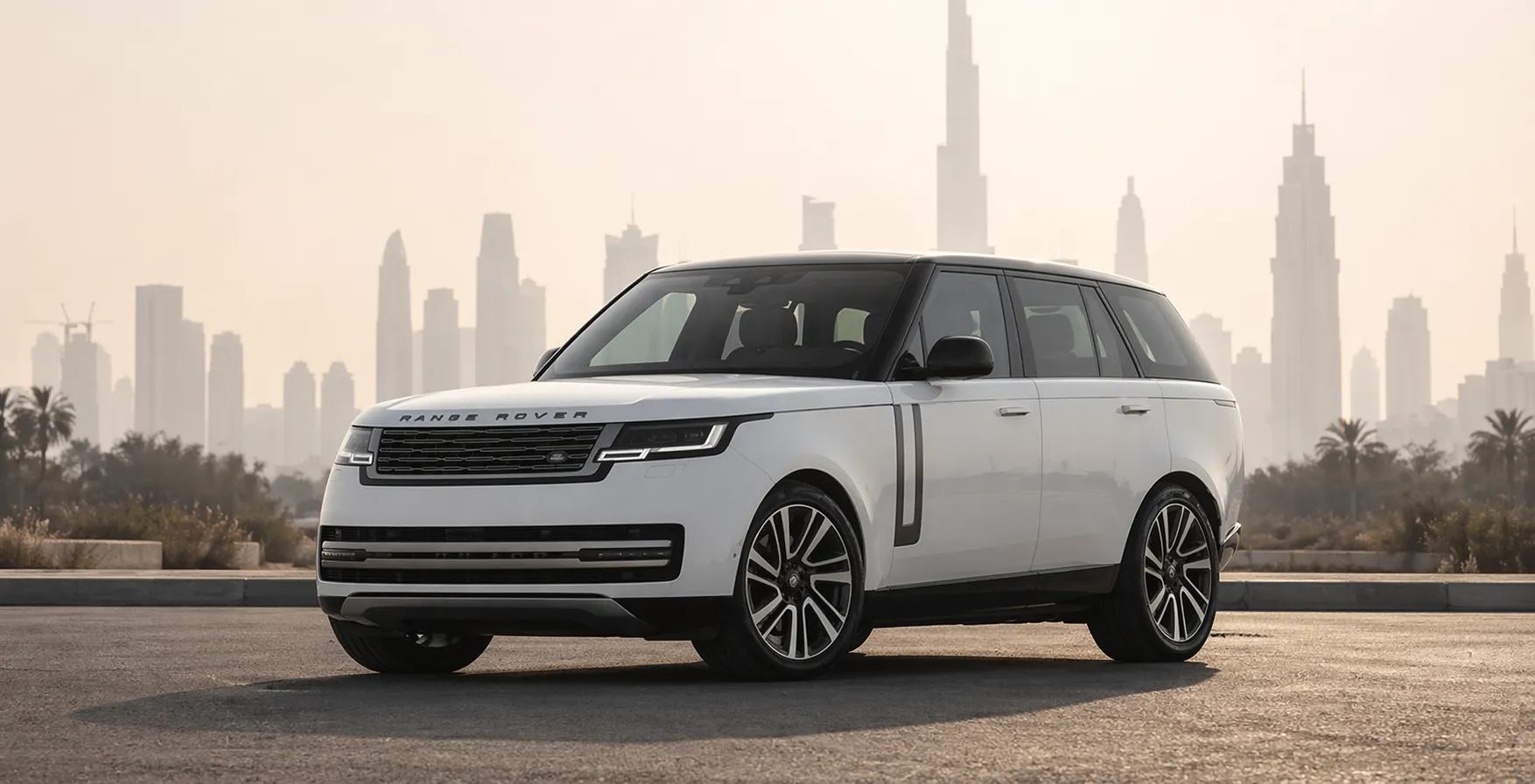 White Range Rover SUV parked in a modern Dubai cityscape with Sheikh Zayed skyline in the background, representing premium Range Rover service center sheikh zayed road automotive luxury and performance.