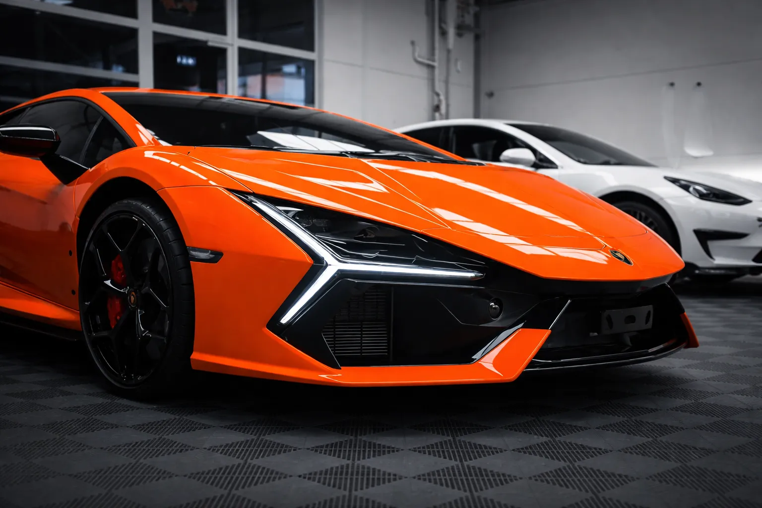 Close-up of an orange Lamborghini inside a modern garage, highlighting its sharp design and performance, often maintained through specialized exotic car repair services.