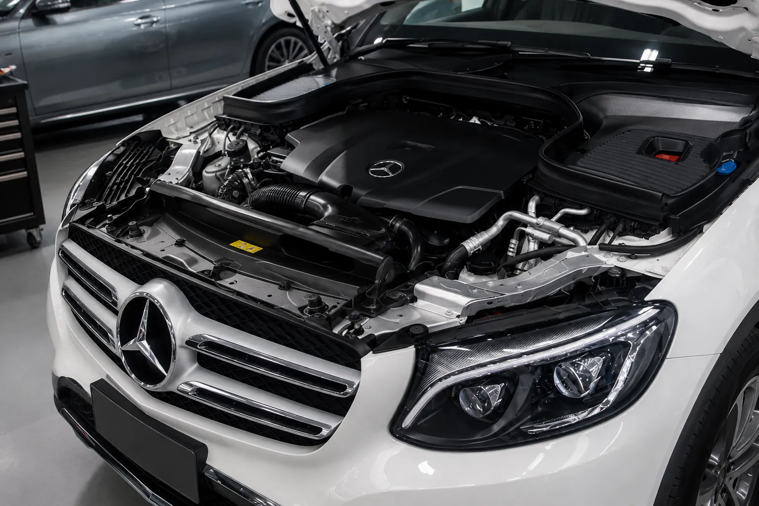 Mercedes auto repair Dubai showing a luxury Mercedes engine bay with hood open for professional inspection and maintenance in a modern garage.